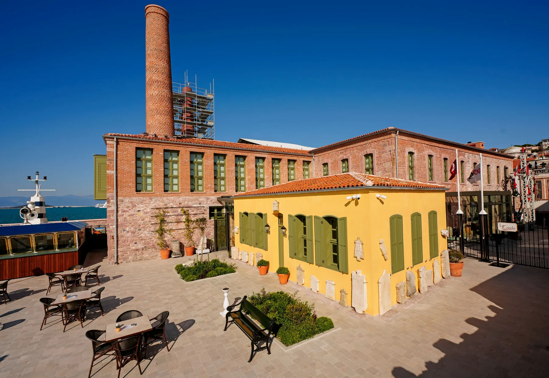 Onarımı tamamlanmış Ayvalık fabrika yapısı, bacası ve avlusuyla